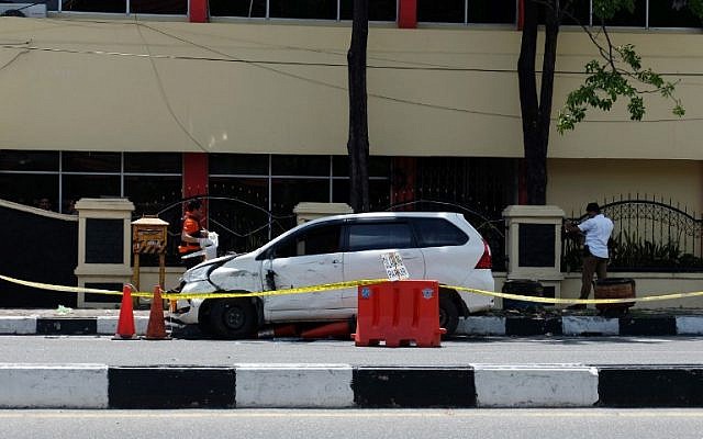 Des policiers indonésiens examinent la voiture utilisée par les terroristes devant le siège de la police à Pekanbaru, à Riau , après l'attentat commis le 16 mai 2018 (Crédit : AFP PHOTO / DEDY SUTISNA Des policiers indonésiens examinent la voiture utilisée par les terroristes devant le siège de la police à Pekanbaru, à Riau , après l'attentat commis le 16 mai 2018 (Crédit : AFP PHOTO / DEDY SUTISNA