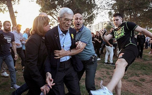 Le maire de la deuxième ville de Grèce - Thessalonique - Yiannis Boutaris, au centre, après avoir été agressé par des membres présumés d'extrême-droite au sein de sa municipalité, le 19 mai 2018 (Crédit : AFP/Eurokinissi/Eurokinissi) Le maire de la deuxième ville de Grèce - Thessalonique - Yiannis Boutaris, au centre, après avoir été agressé par des membres présumés d'extrême-droite au sein de sa municipalité, le 19 mai 2018 (Crédit : AFP/Eurokinissi/Eurokinissi)