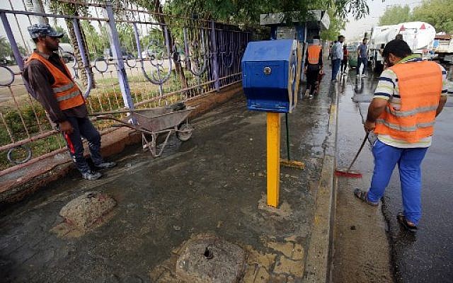 Des employés municipaux irakiens nettoient le lieu d'un attentat suicide qui à eu lieu à Bagdad, dans la nuit du 23 au 24 mai 2018. (Crédit : AFP / AHMAD AL-RUBAYE) Des employés municipaux irakiens nettoient le lieu d'un attentat suicide qui à eu lieu à Bagdad, dans la nuit du 23 au 24 mai 2018. (Crédit : AFP / AHMAD AL-RUBAYE)