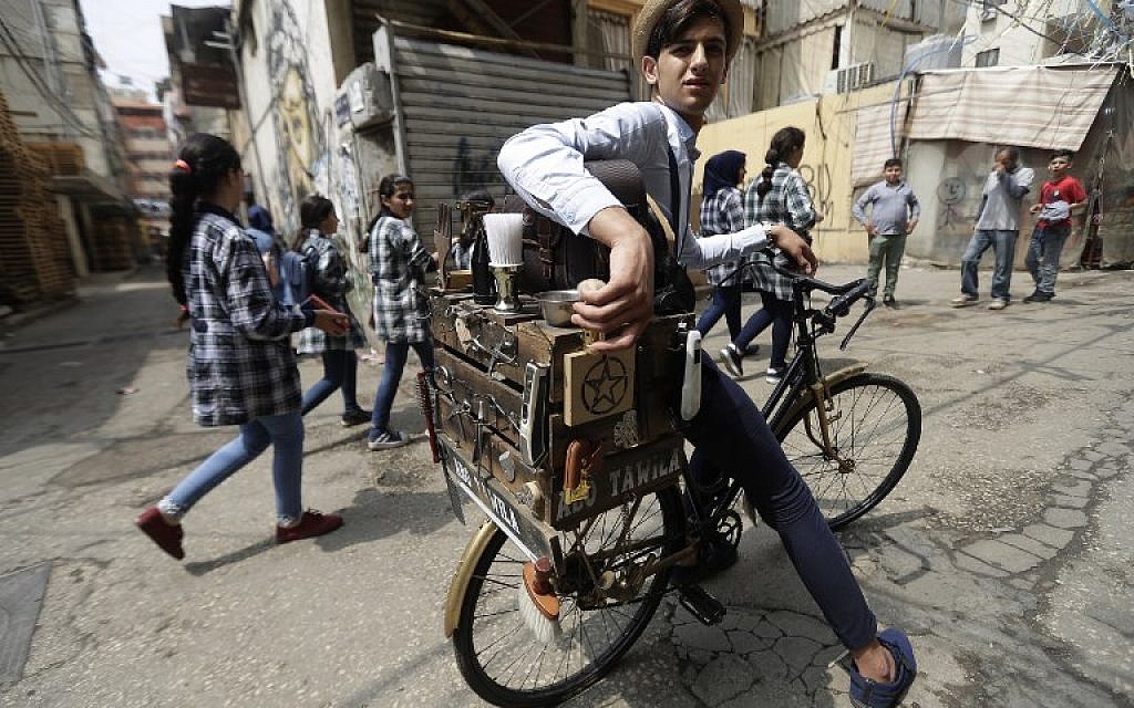 Mohammed, barbier ambulant libanais connu sous le nom de “Abo Tawil,” aux abords du camp de réfugiés palestinien de Burj al-Barajneh, au sud de la capitale de Beyrouth, le 29 mai 2018 (Crédit : AFP PHOTO / JOSEPH EID) Mohammed, barbier ambulant libanais connu sous le nom de “Abo Tawil,” aux abords du camp de réfugiés palestinien de Burj al-Barajneh, au sud de la capitale de Beyrouth, le 29 mai 2018 (Crédit : AFP PHOTO / JOSEPH EID)