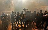 Des Palestiniens transportent un manifestant blessé lors d'affrontements avec les forces israéliennes à proximité de la frontière entre la bande de Gaza et Israël à l'est de la ville de Gaza, le 14 mai 2018 (MAHMUD HAMS / AFP)