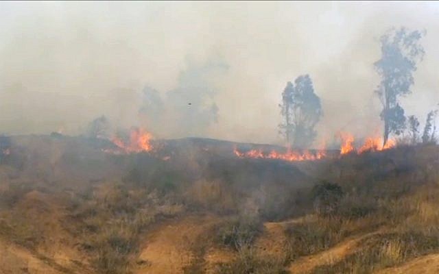 La fumée et les flammes s'élèvent des prairies du kibboutz Beeri dans le sud d'Israël après que des Palestiniens ont fait voler un cerf-volant chargé d'un cocktail Molotov au-dessus de la frontière le 2 mai 2018. (Capture d'écran/Rafi Bavian)