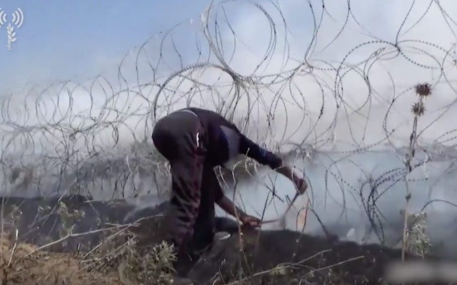 Un Gazaoui avec une pince coupante dans une vidéo des violences du 14 mai diffusée par Tsahal (Crédit : armée israélienne) Un Gazaoui avec une pince coupante dans une vidéo des violences du 14 mai diffusée par Tsahal (Crédit : armée israélienne)