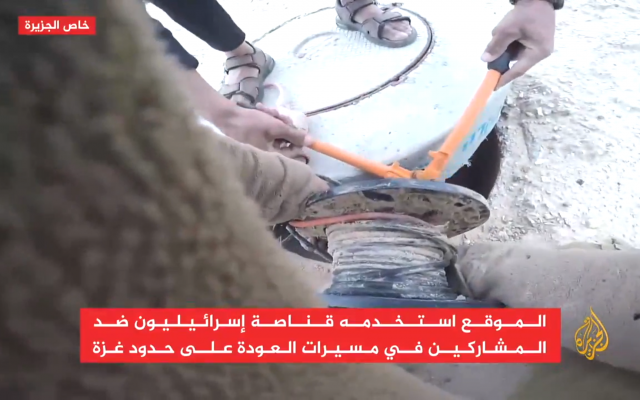 Deux Palestiniens coupent des câbles électriques à un poste militaire israélien à proximité de la bande de Gaza, le 22 mai 2018 (Capture d'écran : Al-Jazeera)