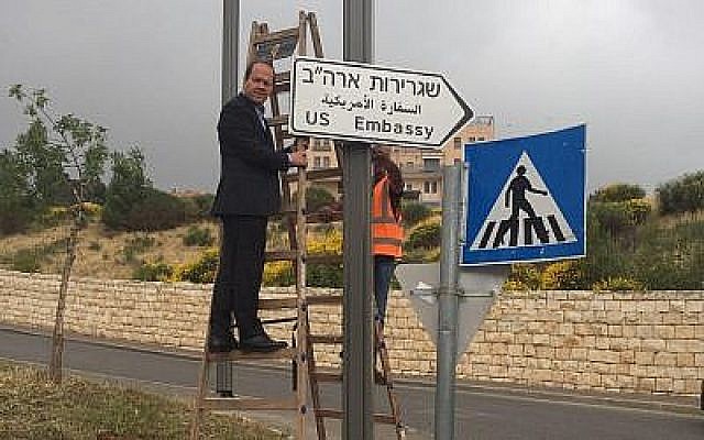Le maire de Jérusalem, Nir Barkat, suspend le premier panneau indiquant la nouvelle ambassade américaine à Jérusalem, le 7 mai 2018. (Municipalité de Jérusalem) Le maire de Jérusalem, Nir Barkat, suspend le premier panneau indiquant la nouvelle ambassade américaine à Jérusalem, le 7 mai 2018. (Municipalité de Jérusalem)