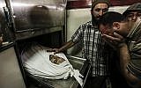 Un Palestinien pleure près du corps de Mohammed al-Radeia, 30 ans, avant ses funérailles à Beit Lahia, dans le nord de la bande de Gaza, le 28 mai 2018. L'homme palestinien a été tué par les tirs de chars israéliens dans le nord de Gaza plus tôt dans la journée, a déclaré le ministère de la Santé dans l'enclave dirigée par le Hamas. Une porte-parole de l'armée israélienne a déclaré à l'AFP que deux hommes palestiniens ont tenté de franchir la clôture de la frontière "avec l'intention de mener une attaque". (AFP PHOTO / MAHMUD HAMS)