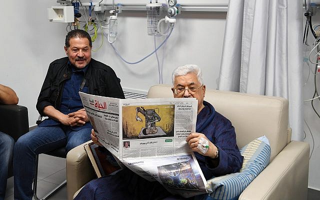 Mahmoud Abbas, président de l'Autorité palestinienne, en convalescence à l'hôpital, lisant un journal au verso duquel figure une caricature représentant un soldat israélien empoisonnant un bébé palestinien, 22 mai 2018. (Agence de presse Wafa) Mahmoud Abbas, président de l'Autorité palestinienne, en convalescence à l'hôpital, lisant un journal au verso duquel figure une caricature représentant un soldat israélien empoisonnant un bébé palestinien, 22 mai 2018. (Agence de presse Wafa)