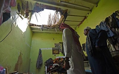 Photo prise le 28 mars 2018 à Um Al-Hammam, un quartier de Riyadh : des ouvriers égyptiens inspectent les dégâts causés par des débris de missiles lancés par les rebelles yéménites, interceptés au dessus de la capitale saoudienne. (Crédit : AFP FAYEZ NURELDINE)