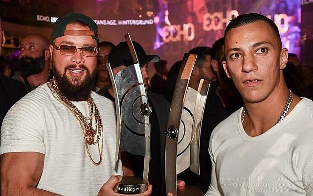 Les rappeurs allemands Kollegah, à gauche, et Farid Bang posent avec leur trophée de l'Echo obtenu dans la catégorie hip/hop musique urbaine, le 12 avril 2018 (Crédit : AFP PHOTO / dpa / Jens Kalaene0 Les rappeurs allemands Kollegah, à gauche, et Farid Bang posent avec leur trophée de l'Echo obtenu dans la catégorie hip/hop musique urbaine, le 12 avril 2018 (Crédit : AFP PHOTO / dpa / Jens Kalaene0