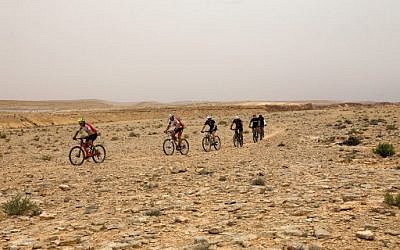 Des cyclistes traversent le désert du Néguev à Machtesh Ramon, le 6 mai 2018. (Crédit :AFP / MENAHEM KAHANA)