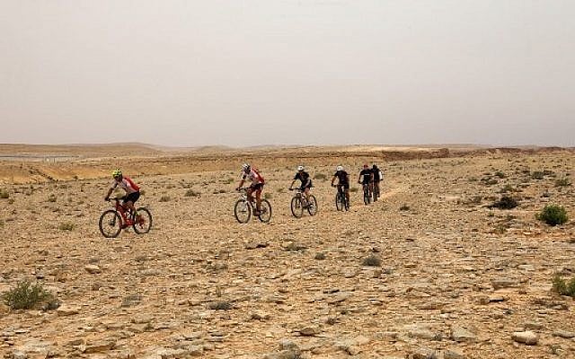 Des cyclistes traversent le désert du Néguev à Machtesh Ramon, le 6 mai 2018. (Crédit :AFP / MENAHEM KAHANA) Des cyclistes traversent le désert du Néguev à Machtesh Ramon, le 6 mai 2018. (Crédit :AFP / MENAHEM KAHANA)
