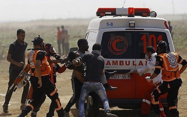 Un Palestinien blessé est évacué durant les affrontements avec les forces israéliennes sur la frontière avec Gaza, aux abords de Jabaliya, le 11 mai 2018 (Crédit :  AFP PHOTO / MOHAMMED ABED)