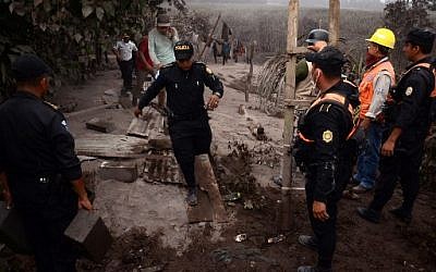 La police dans le village d'El Rodeo, à 35 km au sud de Guatemala City, après l'éruption du volcan de Fuego, le 3 juin 2018. (Crédit : AFP / NOE PEREZ)