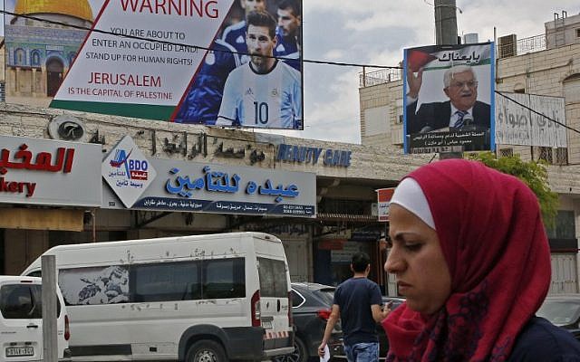 Cette photo du 5 juin 2018 montre une affiche érigée dans la ville de Hébron, en Cisjordanie, appelant au boycott de la star du football Lionel Messi (l) à côté d'un portrait du président de l'Autorité palestinienne Mahmoud Abbas. (AFP PHOTO / HAZEM BADER) Cette photo du 5 juin 2018 montre une affiche érigée dans la ville de Hébron, en Cisjordanie, appelant au boycott de la star du football Lionel Messi (l) à côté d'un portrait du président de l'Autorité palestinienne Mahmoud Abbas. (AFP PHOTO / HAZEM BADER)