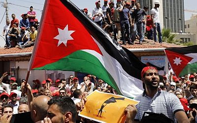 Les manifestants jordaniens brandissent des drapeaux et scandent des slogans durant un rassemblement anti-austérité à Amman, le 6 juin 2018 (Crédit : / AFP PHOTO / AHMAD GHARABLI)