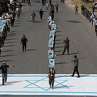 Des paramilitaires chiites alliés à l'Iran marchent sur un drapeau israélien dessiné sur la chaussée lors d'un rassemblement pour marquer la " Journée Al-Quds " (Jour de Jérusalem) initialement lancé par l'Iran en 1979 et tombant le dernier vendredi du mois sacré du Ramadan, à Bagdad, la capitale irakienne, le 8 juin 2018. (AFP Photo/Ahmad al-Rubaye)
