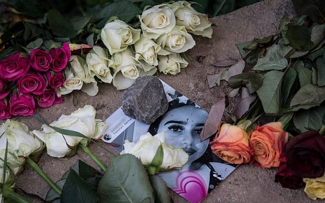 Des roses recouvrent la photo de Susanna Maria Feldman, 14 ans, tuée à Wiesbaden, Allemagne, vendredi 8 juin 2018. (AFP PHOTO / dpa / Boris Roessler)