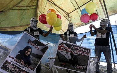 Des manifestants palestiniens préparent des cerfs-volants chargés de matériel combustible pour les faire voler vers Israël, à la frontière entre Israël et Gaza, à al-Bureij, au centre de la bande de Gaza, le 14 juin 2018. (AFP PHOTO / MAHMUD HAMS)