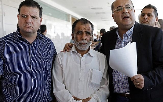 Hussein Dawabsha, au centre, le grand-père d'un enfant Palestinien qui a été grièvement blessé dans un incendie criminel, entouré des députés Ayman Odeh, et Ahmad Tibi, durant le procès des deux auteurs présumés de l'incendie, à lod, le 19 juin 2018. (Crédit : AFP/AHMAD GHARABLI) Hussein Dawabsha, au centre, le grand-père d'un enfant Palestinien qui a été grièvement blessé dans un incendie criminel, entouré des députés Ayman Odeh, et Ahmad Tibi, durant le procès des deux auteurs présumés de l'incendie, à lod, le 19 juin 2018. (Crédit : AFP/AHMAD GHARABLI)