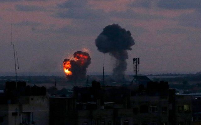 Une explosion vue depuis la ville de Rafah dans le sud de la bande de Gaza après une frappe aérienne des forces israéliennes en riposte aux attaques à la roquette des groupes terroristes palestiniens de l'enclave côtière, le 20 juin 2018 (Crédit : Said Khatib/AFP) Une explosion vue depuis la ville de Rafah dans le sud de la bande de Gaza après une frappe aérienne des forces israéliennes en riposte aux attaques à la roquette des groupes terroristes palestiniens de l'enclave côtière, le 20 juin 2018 (Crédit : Said Khatib/AFP)