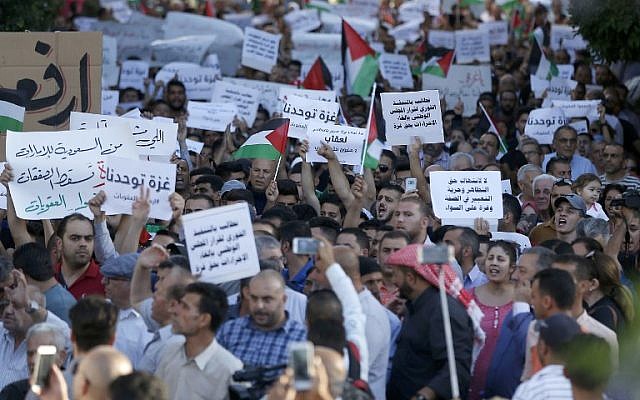 Les Palestiniens participent à une manifestation appelant à la levée des sanctions contre la bande de Gaza, dans la ville de Ramallah en Cisjordanie, le 23 juin 2018. (Crédit : AFP / ABBAS MOMANI)