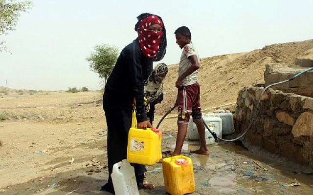 Des Yéménites qui ont fui le conflit à Hodeida, prennent de l'eau dans un village au nord de la province de Hajjah, le 26 juin 2018. (Crédit : ESSA AHMED / AFP)