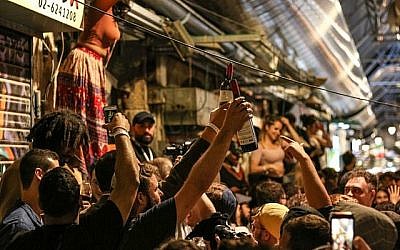 Des Israéliens font la fête dans un bar du marché Mahane Yehuda à Jérusalem, le 8 mai 2018 (Crédit : Liba Farkash/Flash90)
