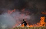 Les pompiers éteignent un feu dans un champ de blé qui avait été allumé par des cerfs-volants incendiaires depuis la bande de Gaza en Israël, le 30 mai 2018 (Crédit : Yonatan Sindel/Flash90)