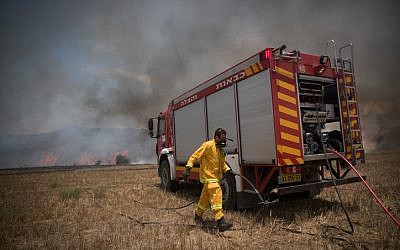 Des pompiers israéliens éteignent un incendie dans un champ dans le sud d'Israël, causé par des cerfs-volants pilotés par des Palestiniens de la bande de Gaza le 5 juin 2018. (Yonatan Sindel/Flash90)