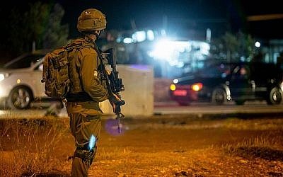 Des soldats israéliens se tiennent près du lieu d'une attaque présumée à l'entrée du village de Husan, en Cisjordanie, le 23 juin 2018. (Flash90)