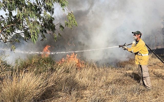 Un pompier éteint un incendie à la frontière israélienne avec Gaza, le 11 juin 2018. (Sam Sokol)