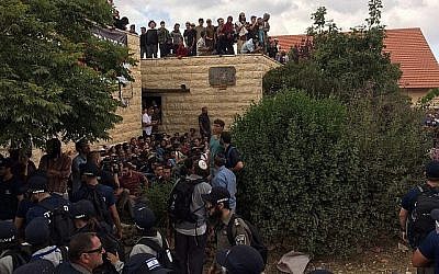Des manifestants à l'avant-poste de Netiv Haavot dans la région du Gush Etzion en Cisjordanie pendant la démolition de l'une des 15 maisons construites illégalement, le 12 juin 2018. (Luke de Tress/Times of Israel)