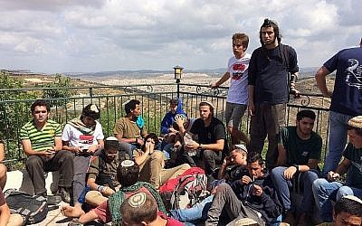 Des manifestants à l'avant-poste de Netiv Haavot, dans la zone du Gush Etzion en Cisjordanie, sur le toit d'une des 15 maisons construites illégalement peu avant leur démolition prévue, le 12 juin 2018. (Luke Tress/Times of Israel)
