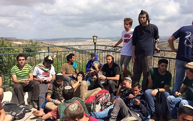 Des manifestants à l'avant-poste de Netiv Haavot, dans la zone du Gush Etzion en Cisjordanie, sur le toit d'une des 15 maisons construites illégalement peu avant leur démolition prévue, le 12 juin 2018. (Luke Tress/Times of Israel)