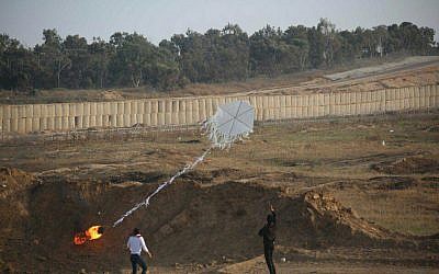 Deux Palestiniens font voler un cerf-volant incendiaire de la bande de Gaza vers le territoire israélien lors de manifestations de masse le long de la clôture de sécurité le 8 juin 2018. (Armée israélienne)
