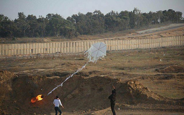 Deux Palestiniens font voler un cerf-volant incendiaire de la bande de Gaza vers le territoire israélien lors de manifestations de masse le long de la clôture de sécurité le 8 juin 2018. (Armée israélienne)