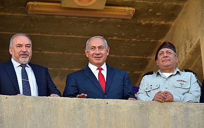 Le Premier ministre Benjamin Netanyahu (au centre), entouré, à gauche du ministre de la Défense Avigdor Liberman et du chef d'état-major Gadi Eizenkot  lors d'une cérémonie pour les nouvelles recrues de l'armée israélienne., le 20 juin 2018;. (Crédit : Ariel Hermoni/Ministère de la Défense)