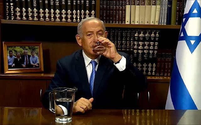 Le Premier ministre Benjamin Netanyahu boit un verre d'eau avant de s'adresser aux Iraniens sur la gestion de la sécheresse, le 10 juin 2018 (Capture d'écran : : YouTube)
