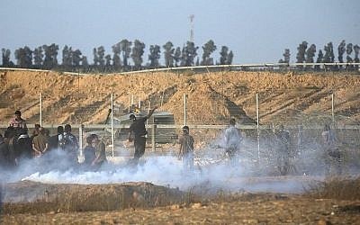 Illustration. Des Palestiniens affrontent les soldats israéliens le long de la frontière entre la bande de Gaza et Israël, à l'est de   Khan Younis, dans le sud de Gaza (Crédit : AFP Photo/Said Khatib)