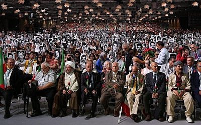 Des gens tiennent des photos de proches tués par le régime iranien lors de l'événement "Iran Libre - l'Alternative"  à Villepinte, au nord de Paris, le 30 juin 2018. (AFP Photo/Zakaria Abdelkafi)