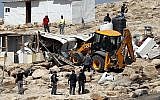 La police israélienne sécurise un bulldozer démolissant des installations dans le village bédouin d'Abu Nuwar, à l'est de Jérusalem, en Cisjordanie, le 4 juillet 2018. (AHMAD GHARABLI/AFP)