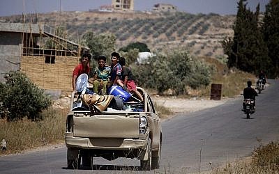 Des Syriens conduisent un véhicule transportant leurs effets personnels alors qu'ils rentrent chez eux dans les villes et villages situés à la périphérie est de Daraa, le 7 juillet 2018. (AFP Photo/Mohamad Abazeed)