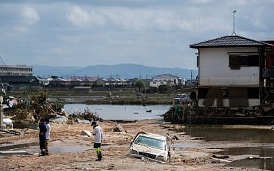 Des gens inspectent leurs maisons endommagées dans une zone touchée par les inondations à Mabi, dans la préfecture d'Okayama, le 10 juillet 2018. (Crédit : AFP / Martin BUREAU)