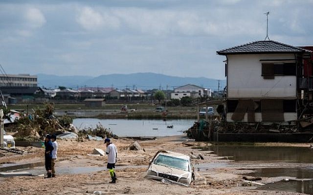 Des gens inspectent leurs maisons endommagées dans une zone touchée par les inondations à Mabi, dans la préfecture d'Okayama, le 10 juillet 2018. (Crédit : AFP / Martin BUREAU)