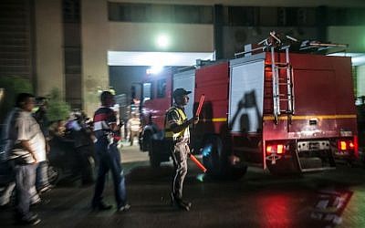 La police et les pompiers égyptiens devant un réservoir chimique après une explosion, près de l'aéroport du Cire, le 12 juillet 2018. (Crédit : AFP/ Khaled DESOUKI)