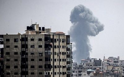 Une fumée s'élève au-dessus des habitations durant des frappes aériennes israéliennes à Gaza City, le 14 juillet 2018 (Crédit : AFP PHOTO / MAHMUD HAMS)
