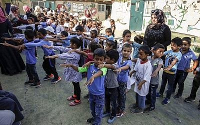 Des enfants rassemblés dans la cour d'une école avant la rentrée scolaire, dans le village de Khan al-Ahmar, en Cisjordanie, le 16 juillet 2018. (Crédit : ABBAS MOMANI/AFP)