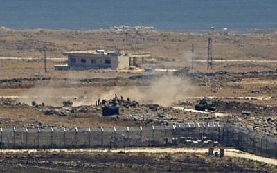 Une photo prise depuis le plateau du Golan israélien montre des rebelles syriens aux côtés d'un tank et d'un canon d'artillerie à proximité de la frontière, dans la province de Quneitra, dans le sud-est de la Syrie, alors que les forces gouvernementales mènent l'assaut, le 16 juillet 2018 (Crédit : AFP Photo/Jalaa Marey)