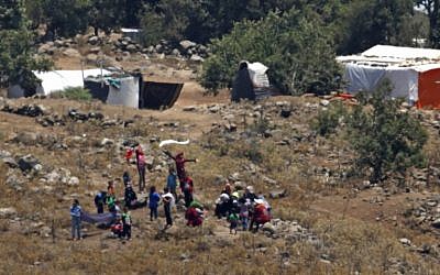 Une photo prise depuis le plateau du Golan montre les réfugiés venant à la frontière entre la Syrie et Israël depuis un camp de personnes déplacées situé  à proximité du village syrien de Burayqah, dans le sud de la province de Quneitra, le 17 juillet 2018. (Crédit : AFP /JALAA MAREY)Y