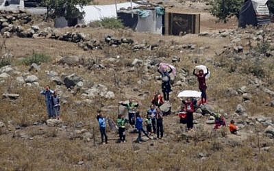 Des civils syriens, déplacés en raison des combats dans le sud-ouest du pays, s'approchent de la barrière frontalière entre la Syrie et Israël, dans le village syrien de Bariqu dans la province de Quneitra, le 17 juillet 2018 (AFP /JALAA MAREY).